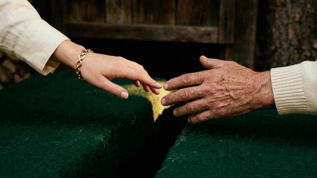 Charity in Islam two hands reaching toward each other across gap