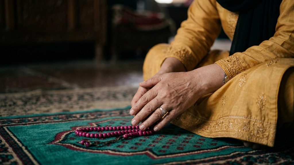 Close view of a Muslim woman's hands and the prayer beads during the Dua After Salah.
