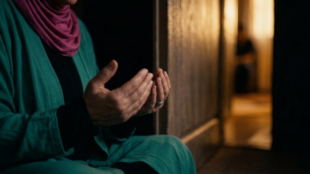 Close view of a Muslim woman's hands and the closed door during the Dua Against Temptations.