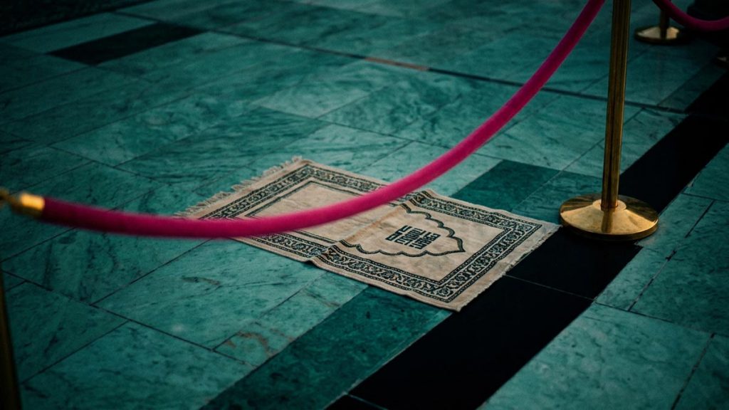 A still-life of a marked place of prayer on the courtyard marble, illustrating the Dua at Maqam Ibrahim.