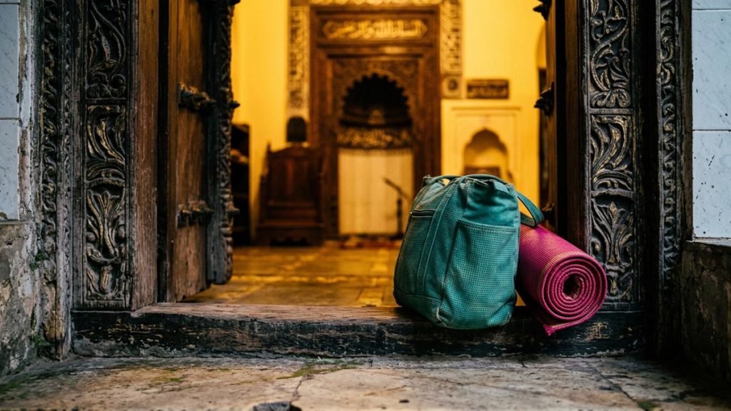 A still-life of a packed bag and a rolled mat at a mosque entrance, illustrating the Dua Before Itikaf.