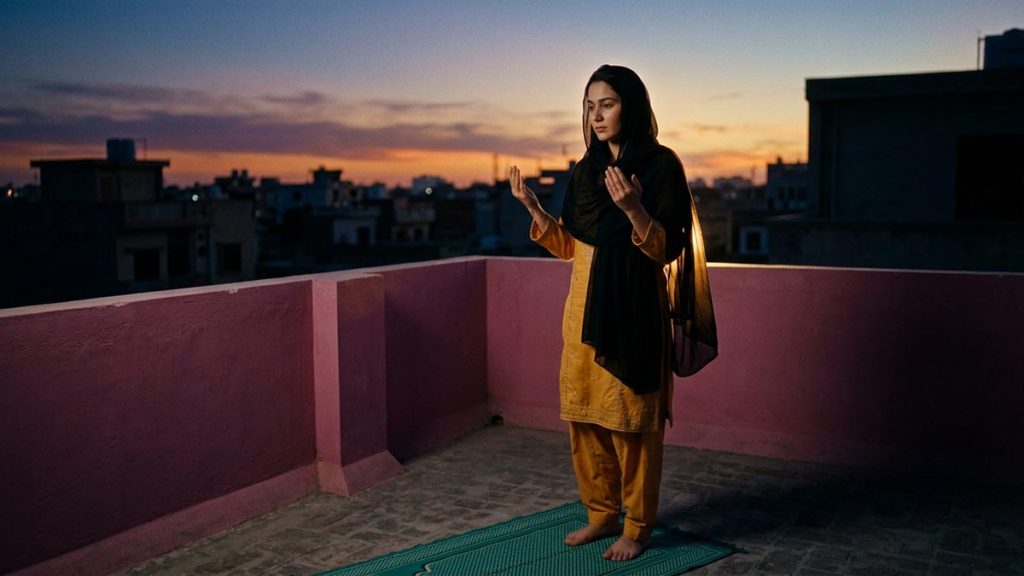 A Muslim woman on a rooftop terrace as the sun sets, an opening scene for the Dua Before Maghrib.