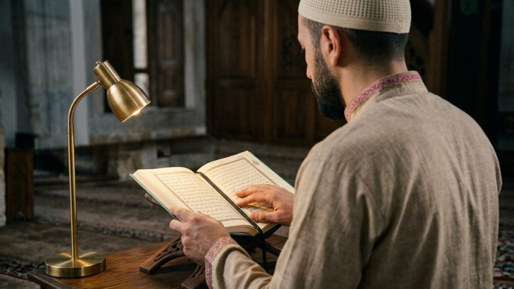 A Muslim man seen from behind at a low table with a carved wooden Quran stand, reflecting the Dua Before Reading the Quran.