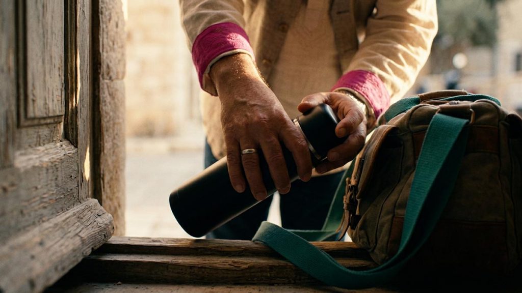 Close view of a Muslim man's hands and the packed work bag during the Dua Before Starting the Day.