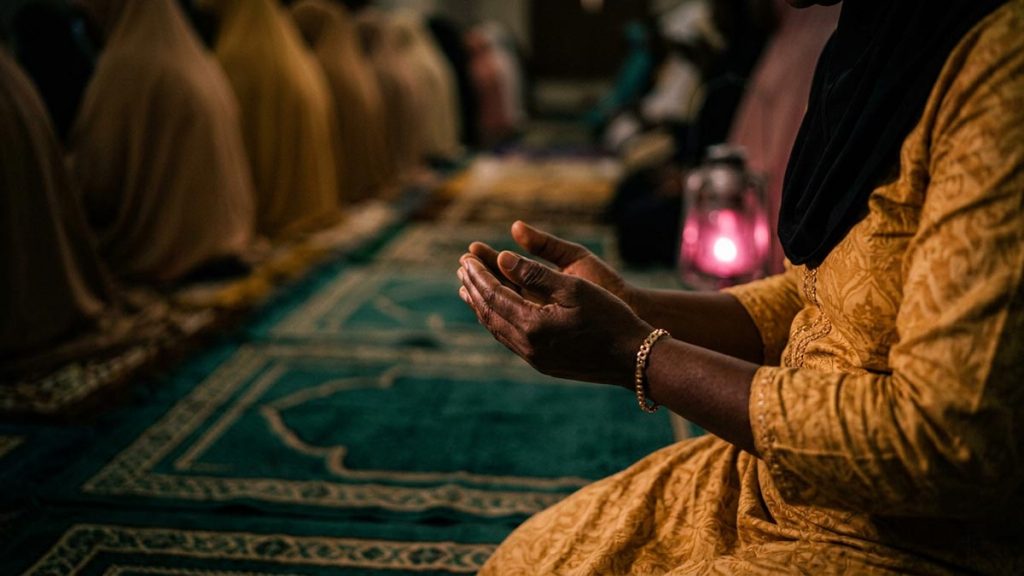 Close view of a Muslim woman's hands and the rows of prayer mats during the Dua Before Taraweeh.