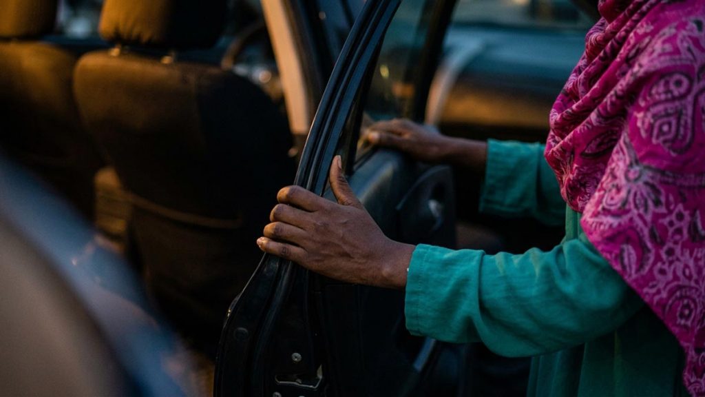 Close view of a Muslim woman's hands and the open car door during the Dua for Boarding a Vehicle.