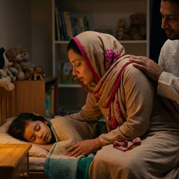 A Muslim family making the Dua for Children’s Protection, in a child's bedroom at bedtime.
