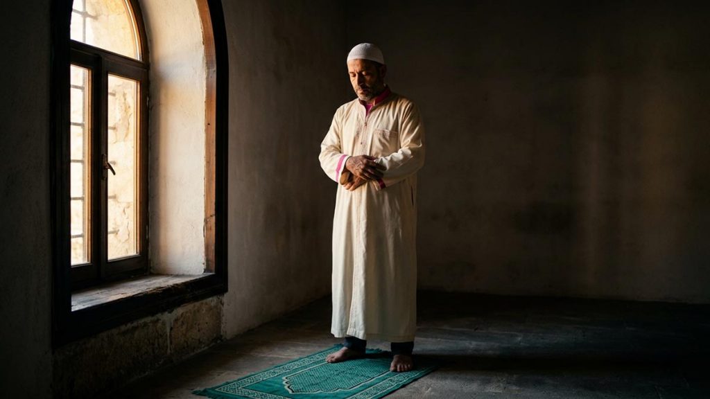 A Muslim man in a bare, quiet room free of distraction, an opening scene for the Dua for Concentration in Salah.