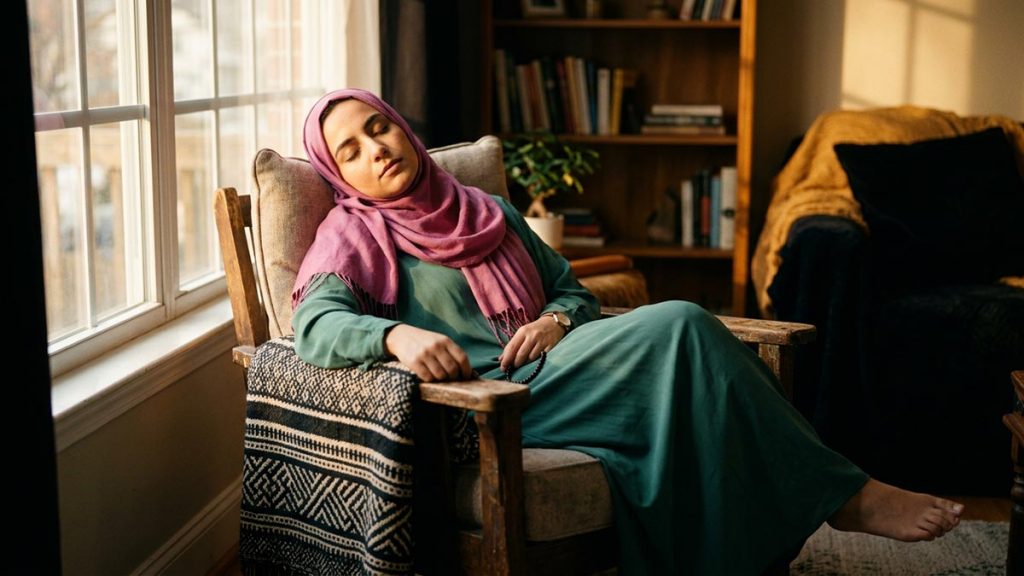 A Muslim woman in a sunlit room where someone rests mid-afternoon, an opening scene for the Dua for Fatigue.