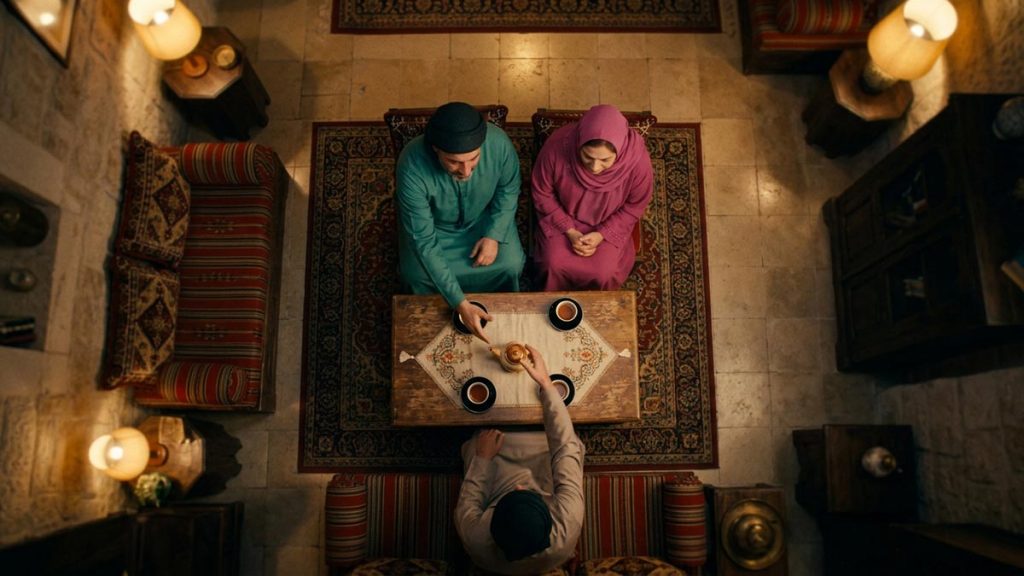 A Muslim family seen from behind in a sitting room where a hand is extended in peace, reflecting the Dua for Forgiving Others.