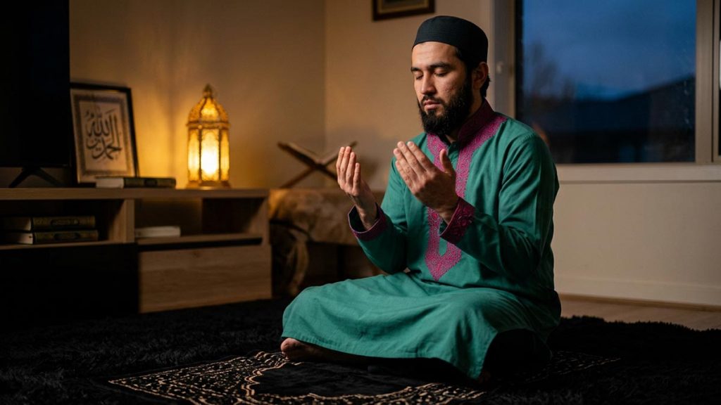 A Muslim man in a home prayer corner at dusk, an opening scene for the Dua for Protection.