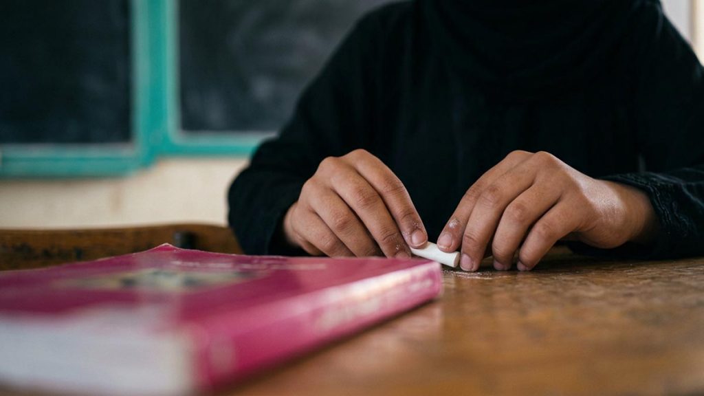Close view of a Muslim family's hands and the chalk during the Dua for Teachers.