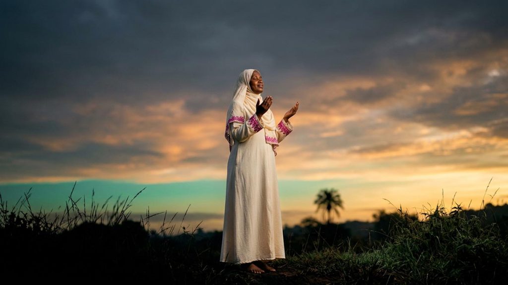 A Muslim woman beneath a vast open sky at first light, an opening scene for the Dua for the Day of Judgement.