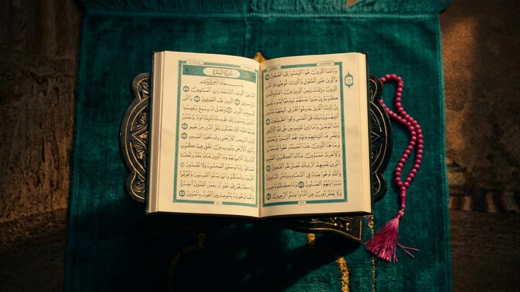 A still-life of an open Quran turned to an early chapter beside prayer beads at dawn, illustrating the Dua of Prophet Adam.