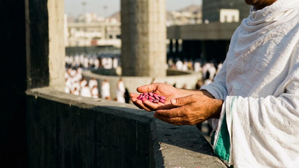 Close view of a Muslim pilgrim's hands and the small pebbles held ready during the Dua When Throwing the Jamarat.