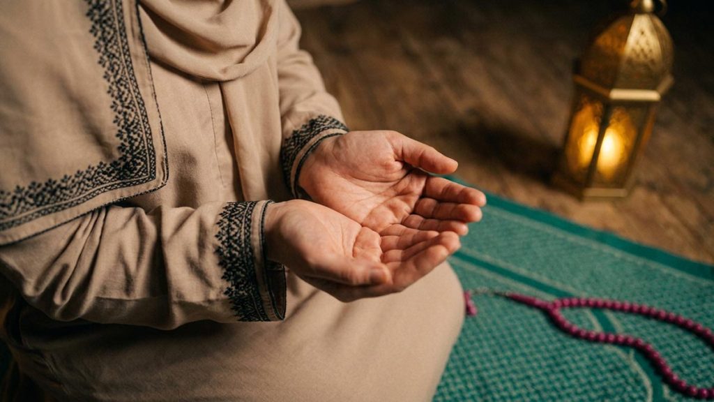 Close view of a Muslim woman's hands and the prayer mat during the Istikharah Dua.