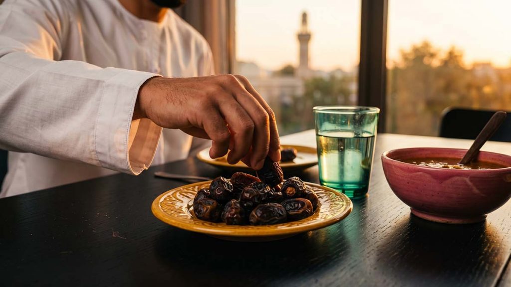 Muslim hand reaching for a date to break the Ramadan fast at Iftar
