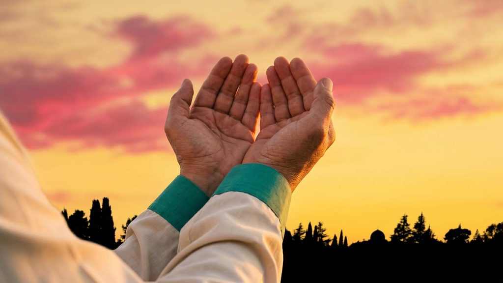 Muslim hands raised in supplication after Janaza funeral prayer at sunset