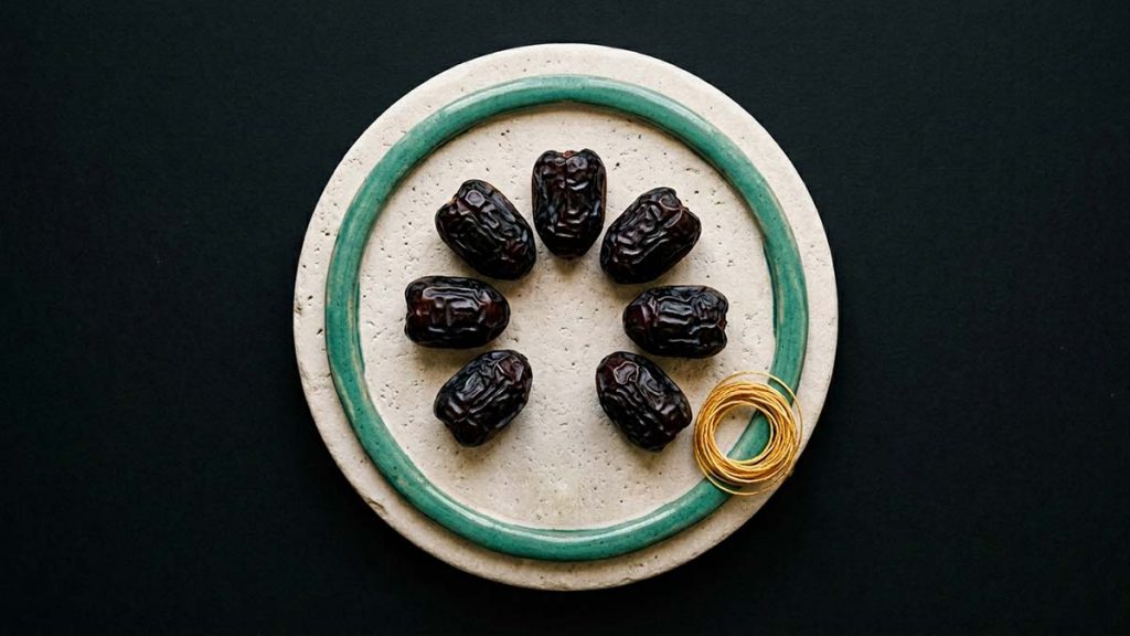 Seven Ajwa Dates arranged in a circle on a stone plate
