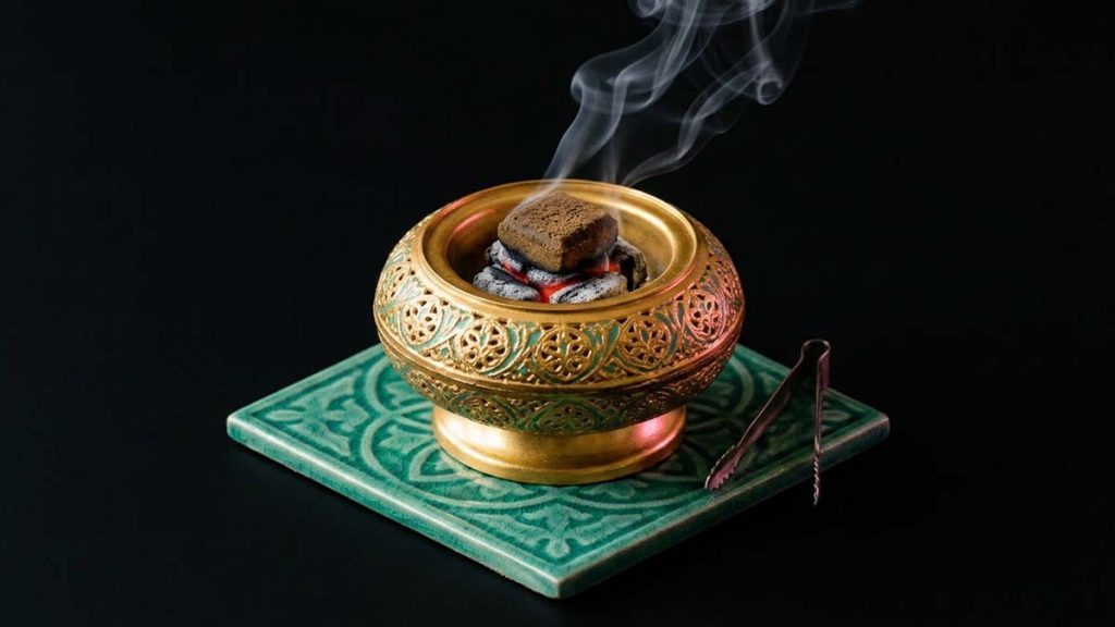 A Bakhoor burner with a block on charcoal, burning incense safely