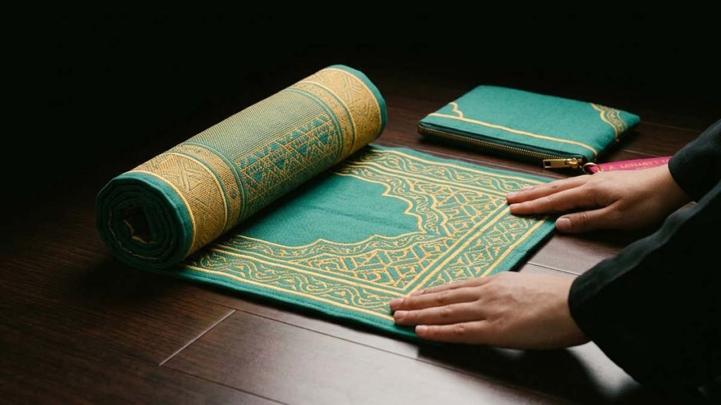 Hands unrolling a Travel Prayer Mat on a clean floor