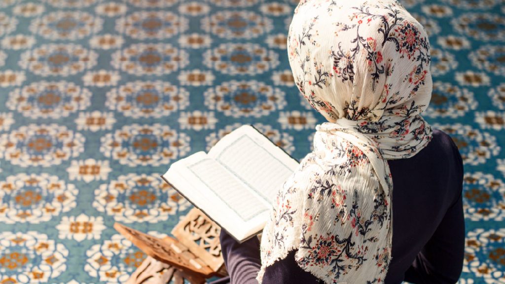Woman reading the Quran in a mosque